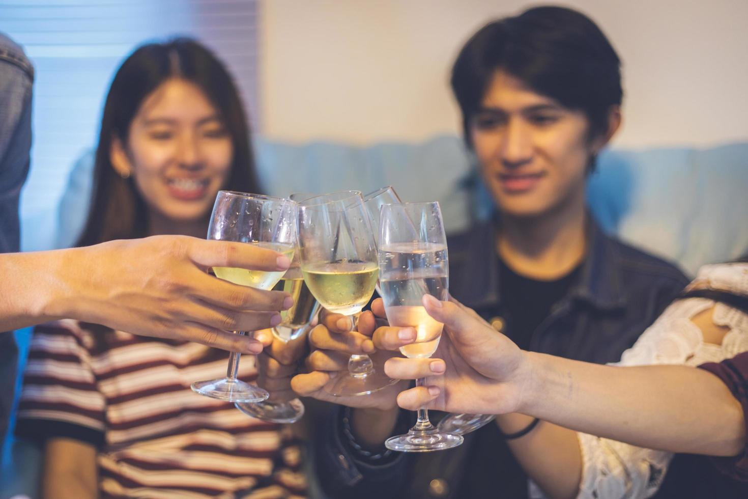 gruppo asiatico di amici che fanno festa con bevande alcoliche e giovani che si divertono in un bar che tostano cocktail.soft focus foto