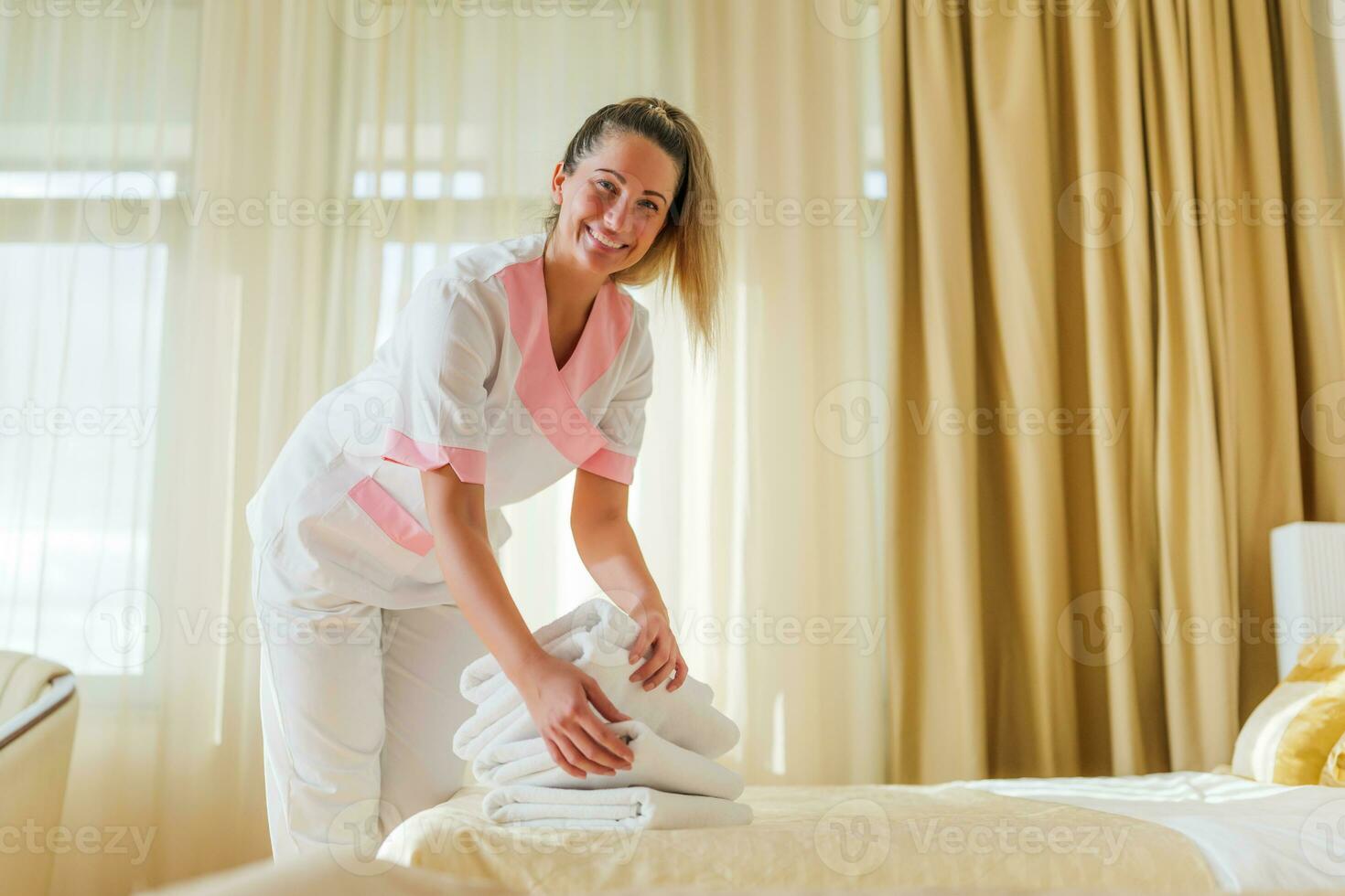bellissimo Hotel domestica mettendo fresco e pulito asciugamani su letto nel camera foto