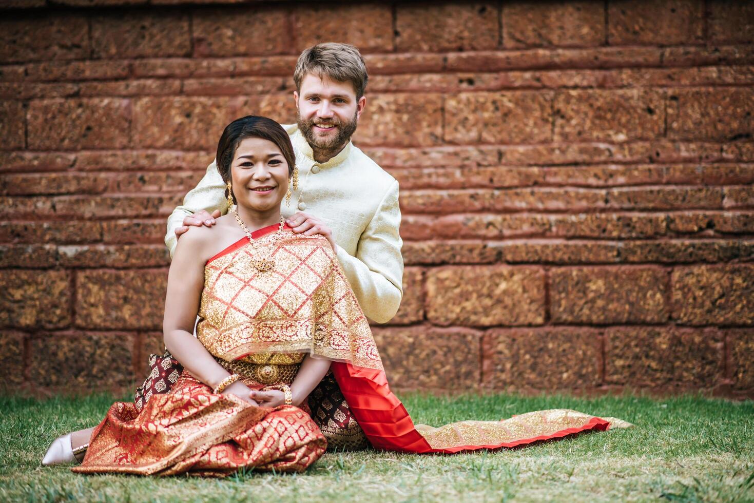 la sposa asiatica e lo sposo caucasico hanno un momento romantico con il vestito thailandese foto