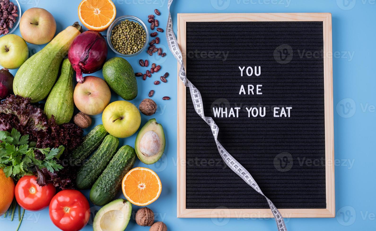 verdure fresche e frutta per una dieta sana, metro a nastro e lavagna nera con le parole sei quello che mangi vista dall'alto piatto con spazio di copia foto