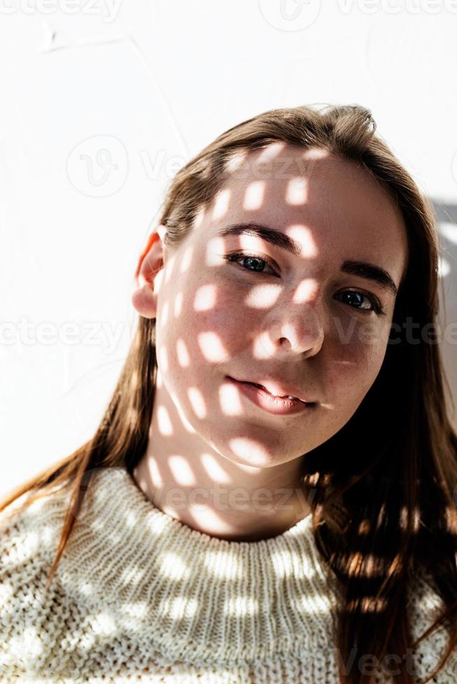 ritratto di una bellissima giovane donna con un motivo di ombre sul viso e sul corpo foto