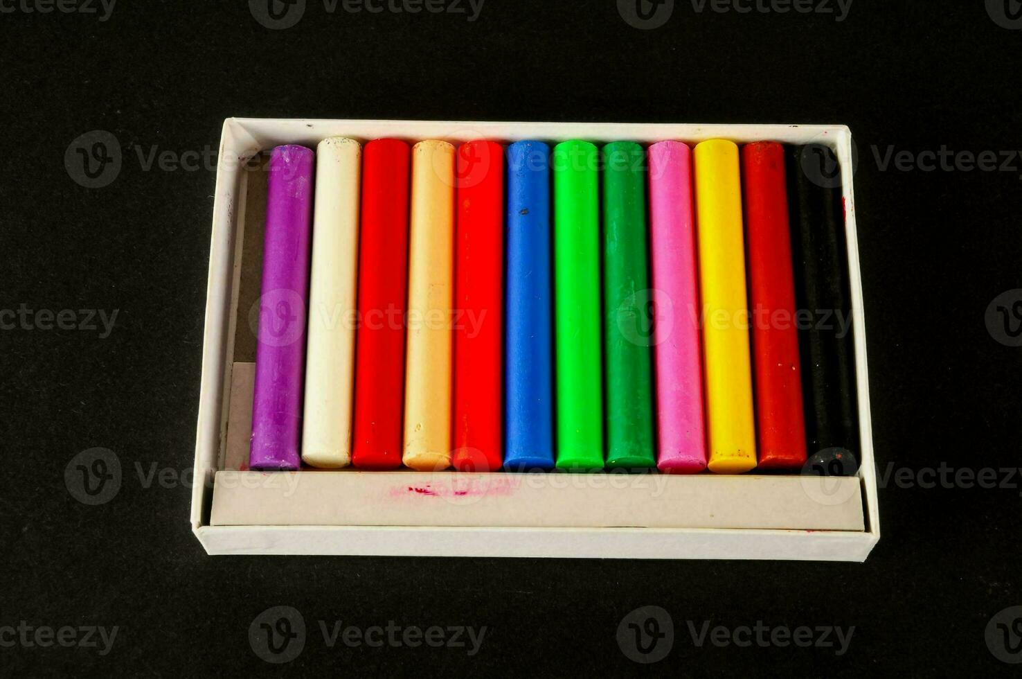 un' scatola di colorato pastelli nel un' bianca scatola foto
