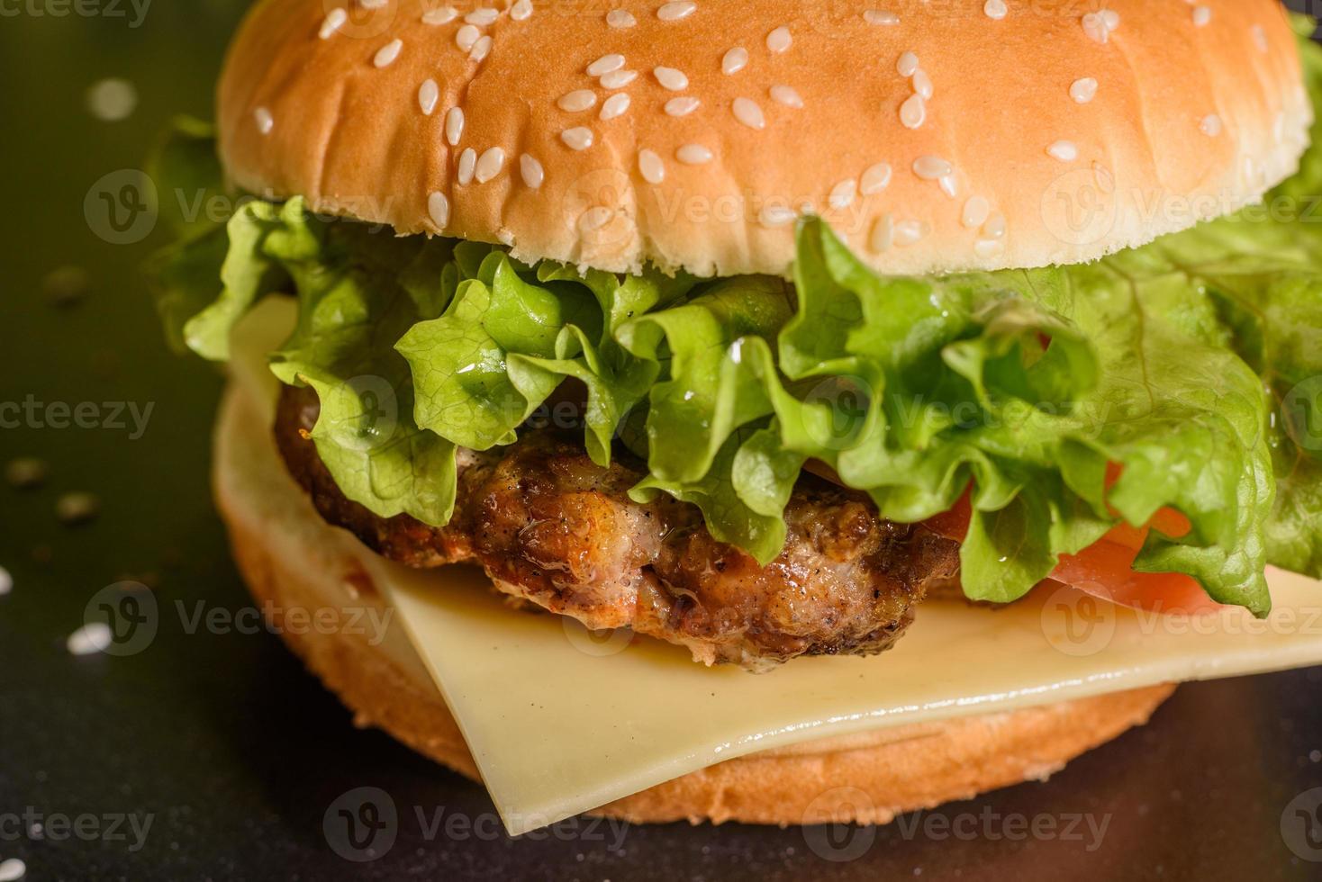 gustoso hamburger fatto in casa alla griglia con manzo, pomodoro, formaggio, cetriolo e lattuga foto