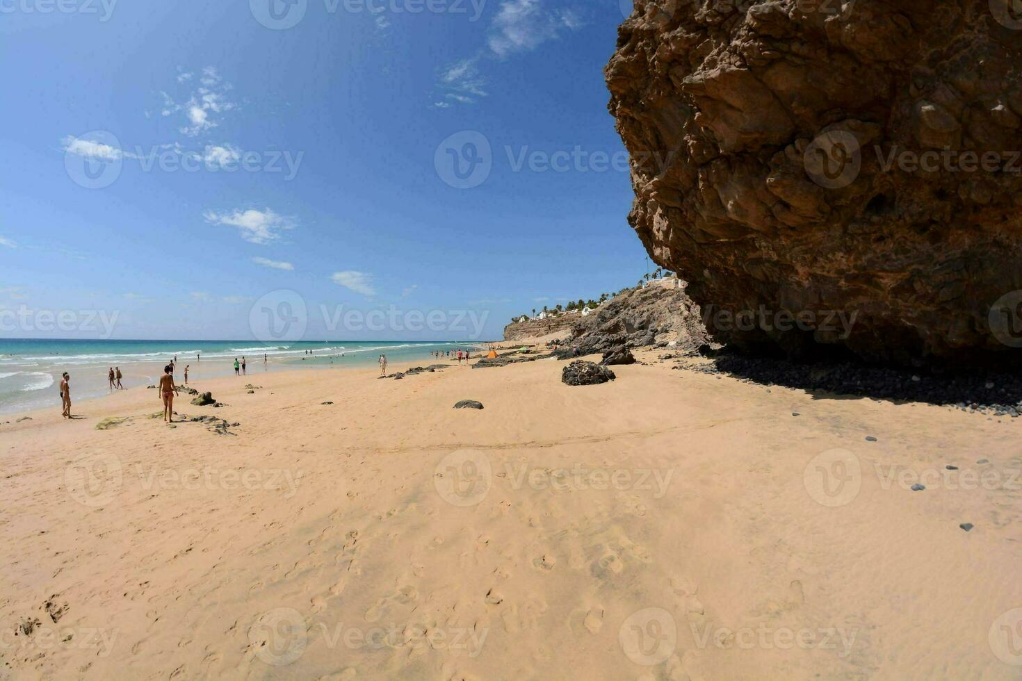 un' sabbioso spiaggia con onde e rocce su il riva foto