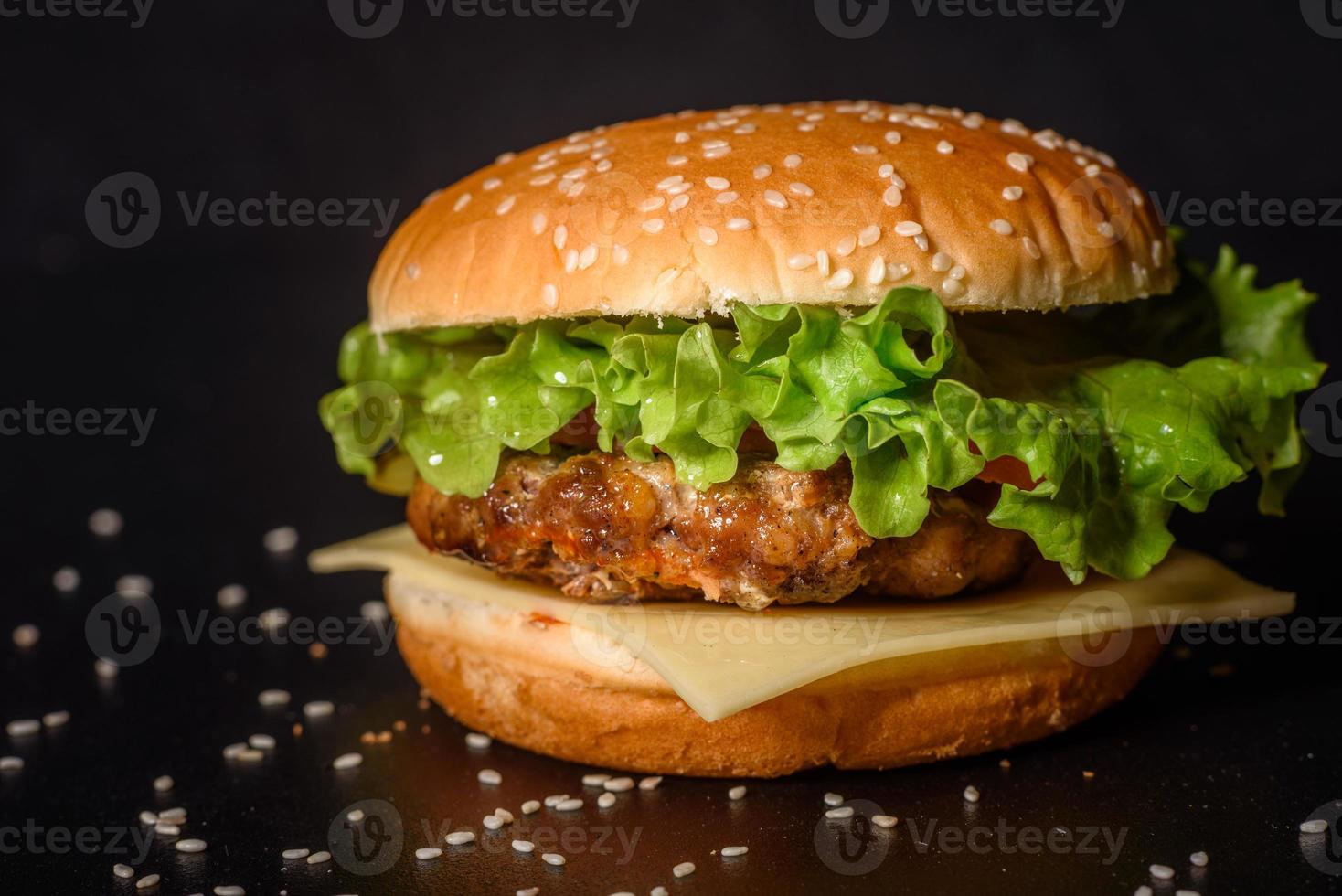 gustoso hamburger fatto in casa alla griglia con manzo, pomodoro, formaggio, cetriolo e lattuga foto