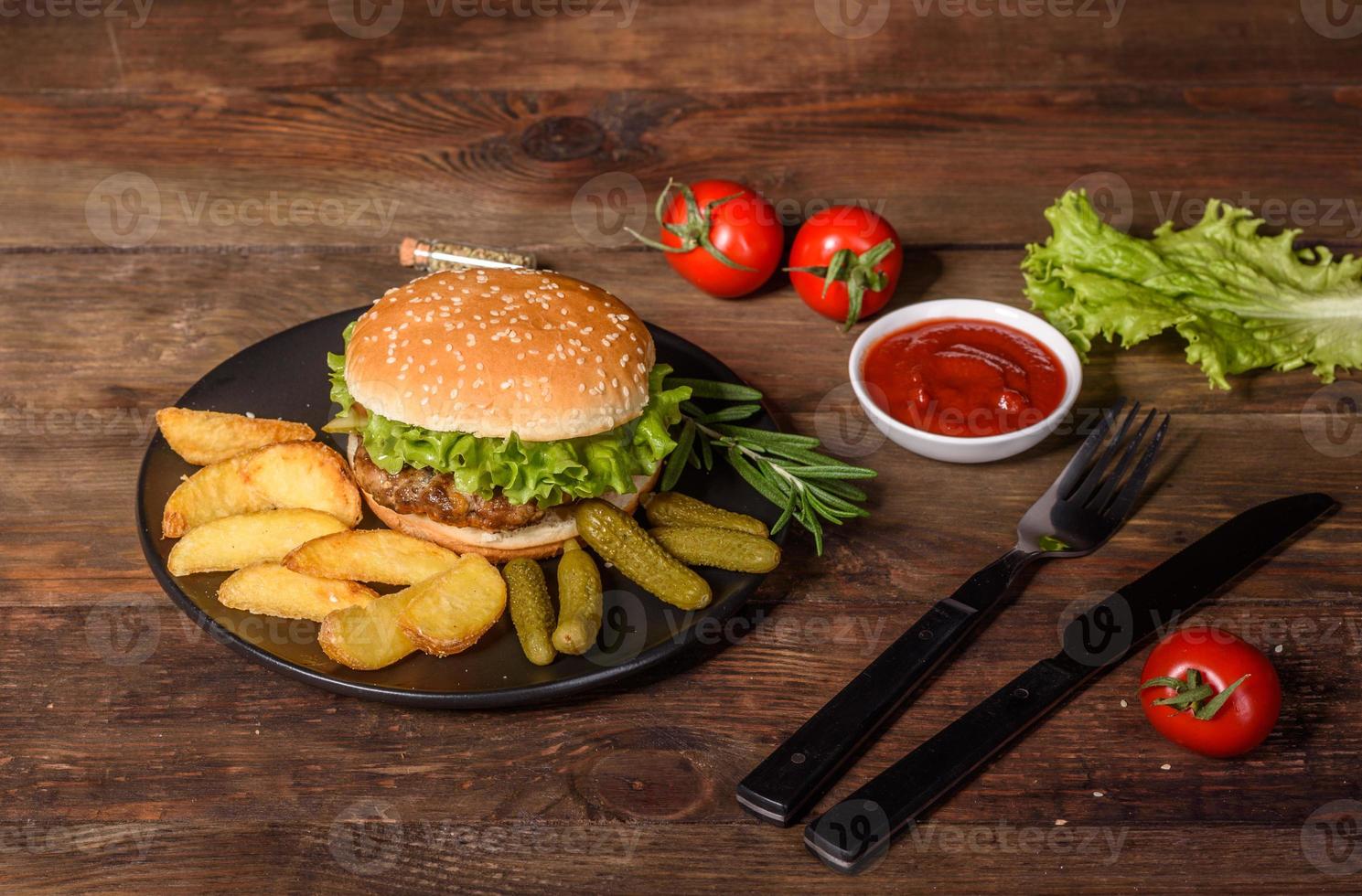 gustoso hamburger fatto in casa alla griglia con manzo, pomodoro, formaggio, cetriolo e lattuga foto