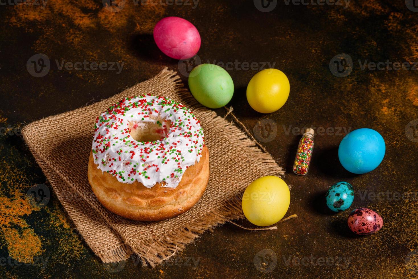 torta di pasqua e uova colorate su sfondo scuro foto