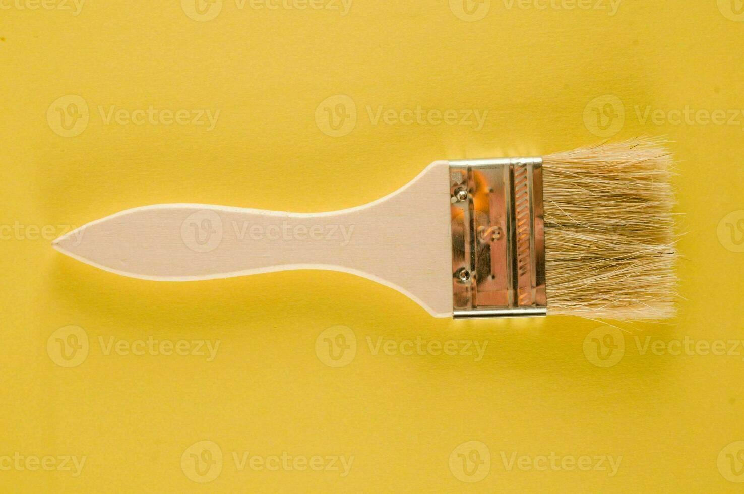 un' dipingere spazzola con un' giallo sfondo foto