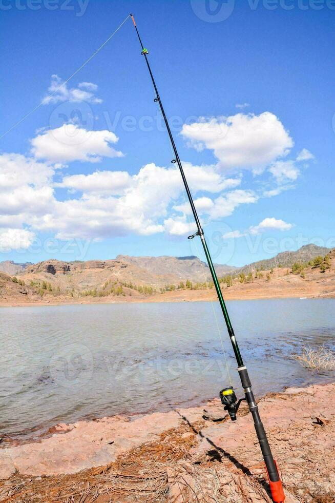 un' pesca asta su il riva di un' lago foto