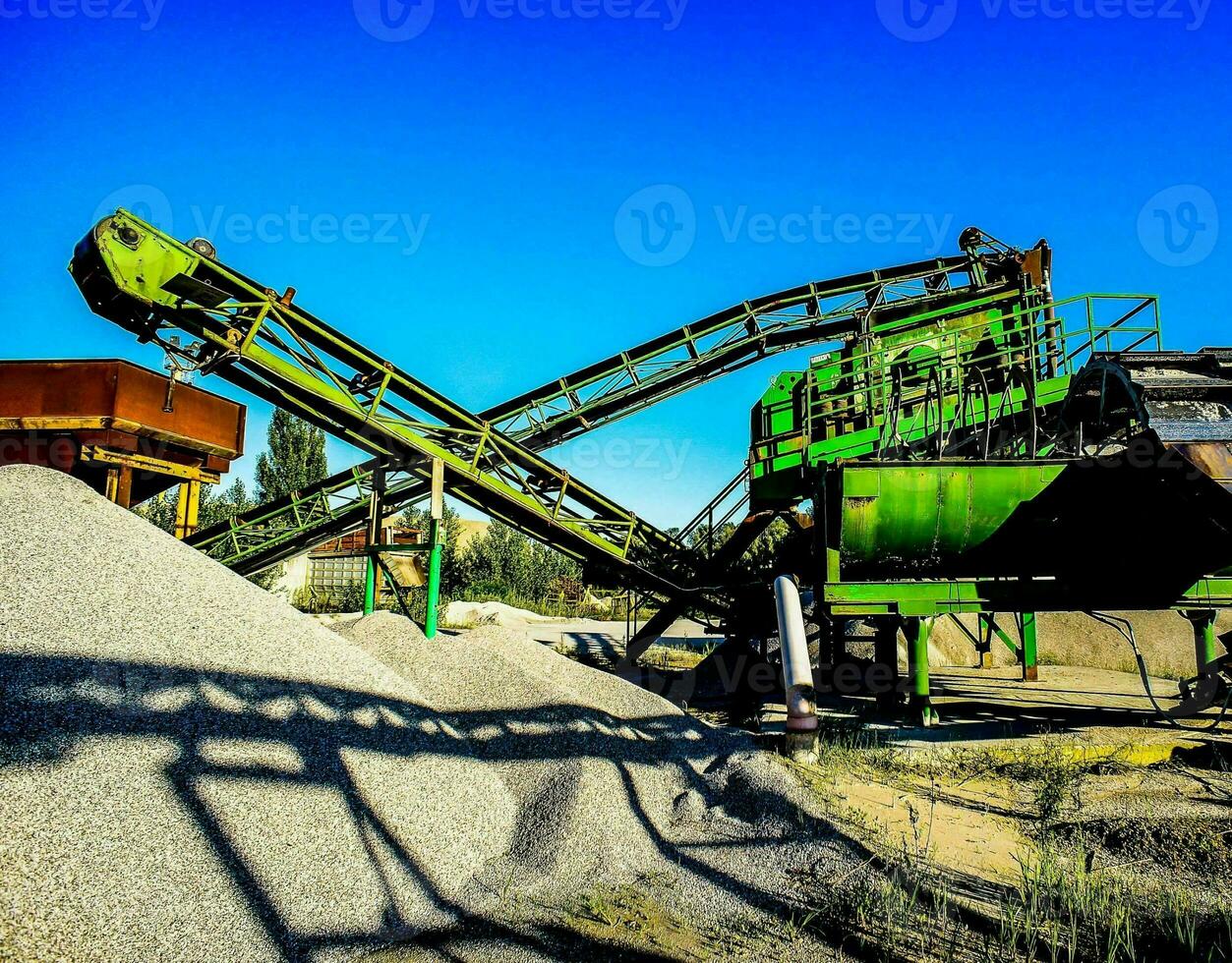 un' grande verde macchina è seduta su superiore di ghiaia foto