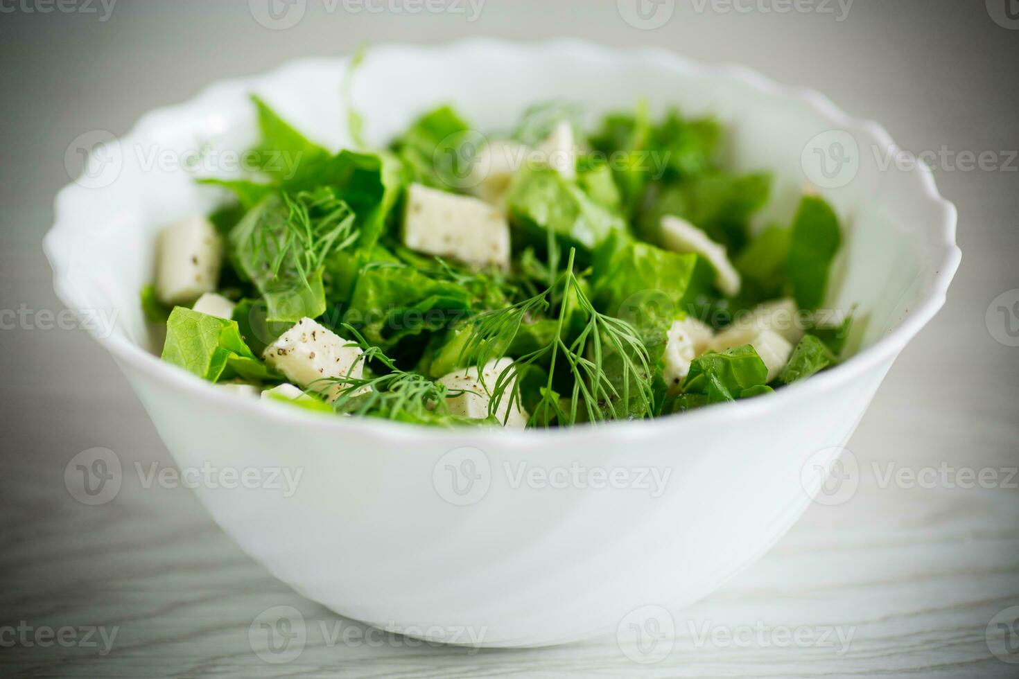 fresco verde lattuga insalata con Mozzarella e erbe aromatiche nel un' ciotola foto
