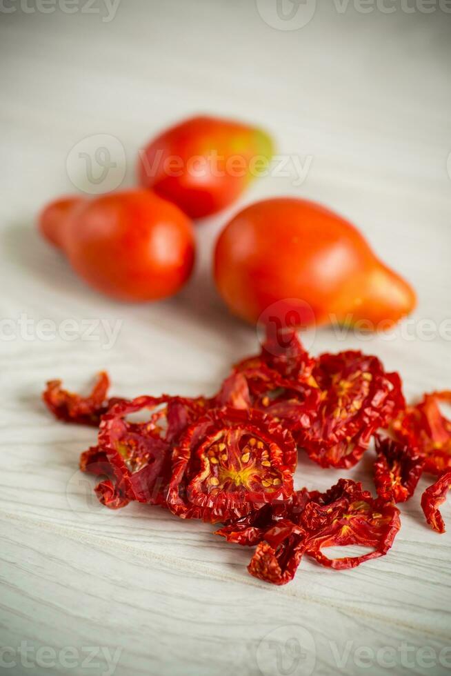 un' manciata di secco pomodori e fresco pomodori foto