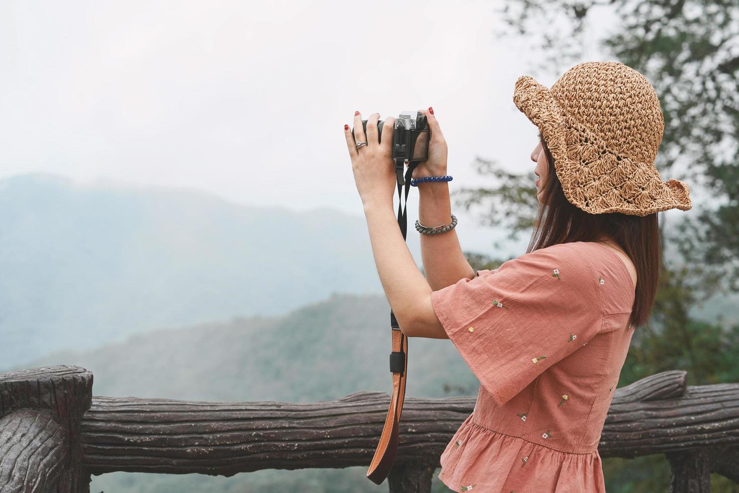 giovane bella donna asiatica viaggiatrice che utilizza la fotocamera digitale compatta e sorride, guardando lo spazio della copia. stile di vita viaggio viaggio, esploratore di viaggi mondiali o concetto di turismo estivo in asia foto