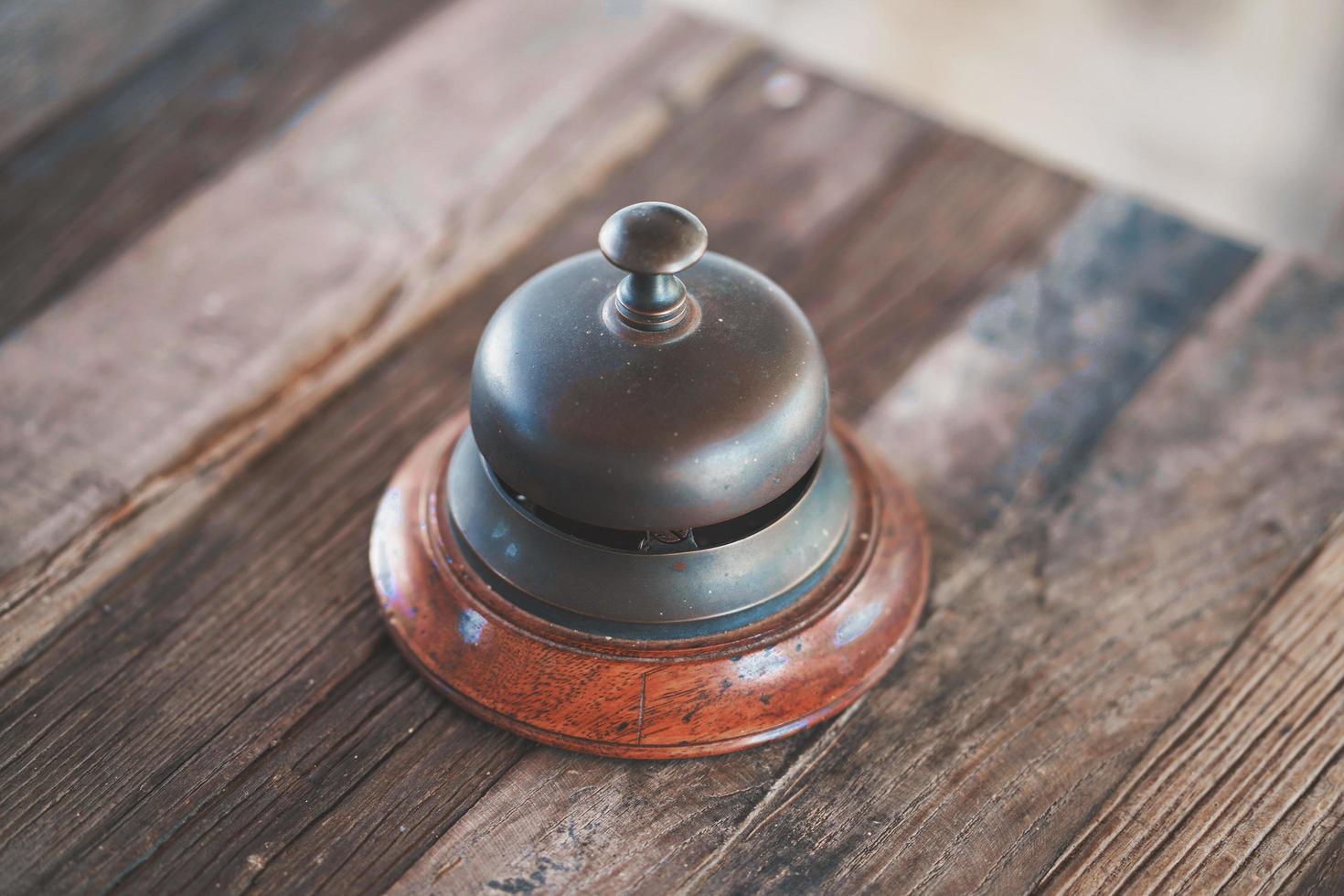 campanello d'epoca della reception dell'hotel sul tavolo di legno. vecchio stile retrò foto