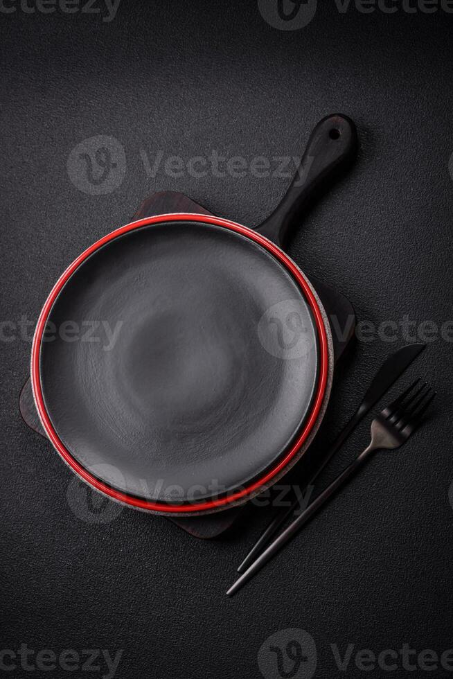 accidentato vuoto ceramica piatto su un' strutturato calcestruzzo sfondo foto