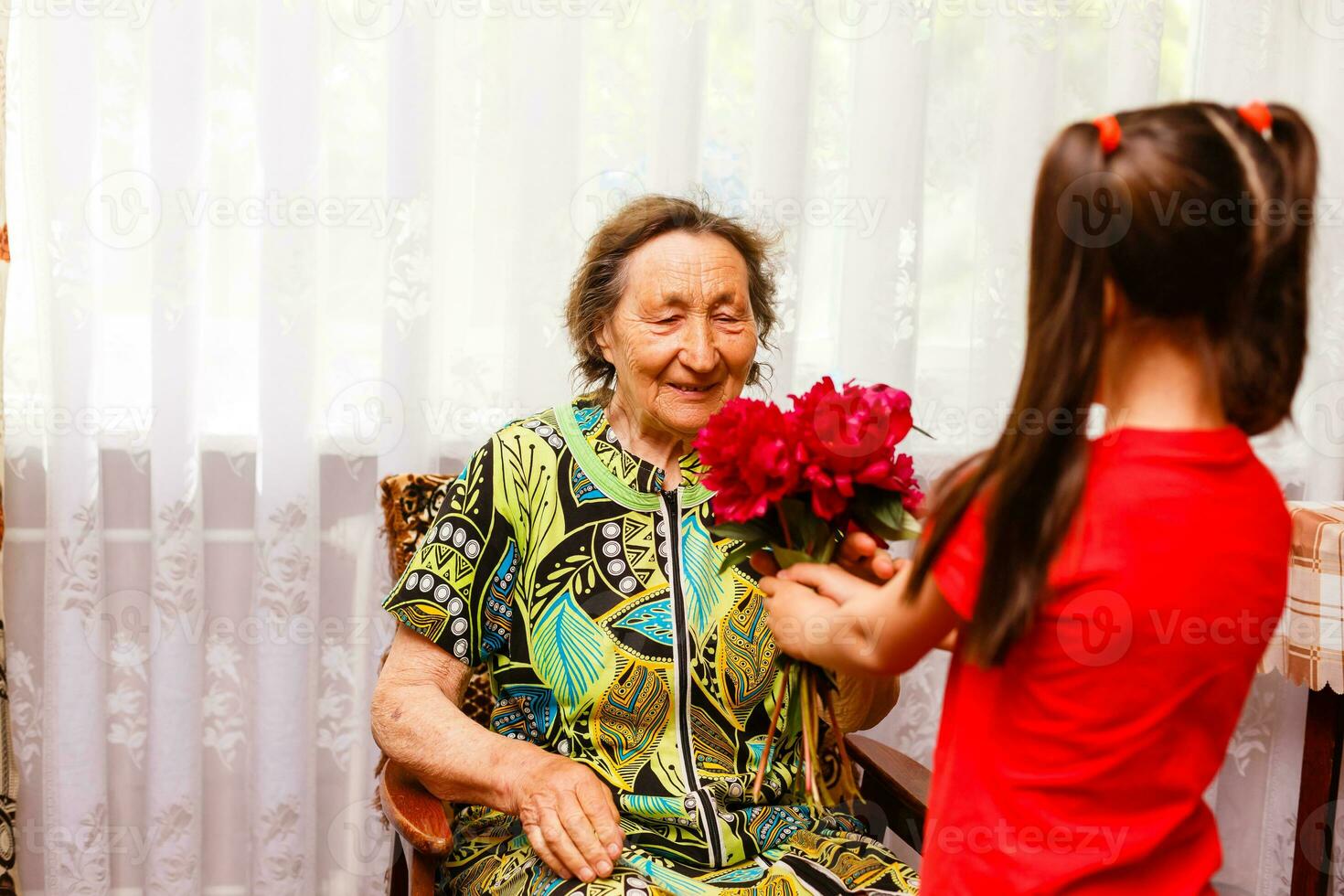 poco ragazza dando sua grande nonna un' rosa fiore foto