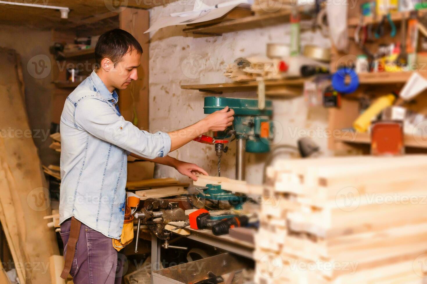 soddisfatto allegro gioioso sorridente maestro del legno è in piedi vicino del desktop nel il suo officina, stazione di lavoro foto