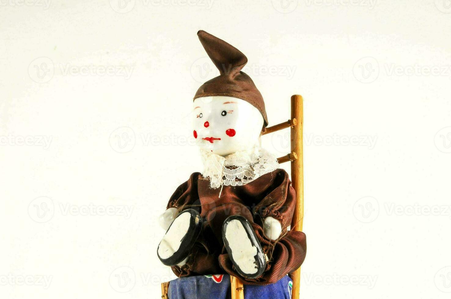un' piccolo Bambola seduta su un' di legno sedia foto