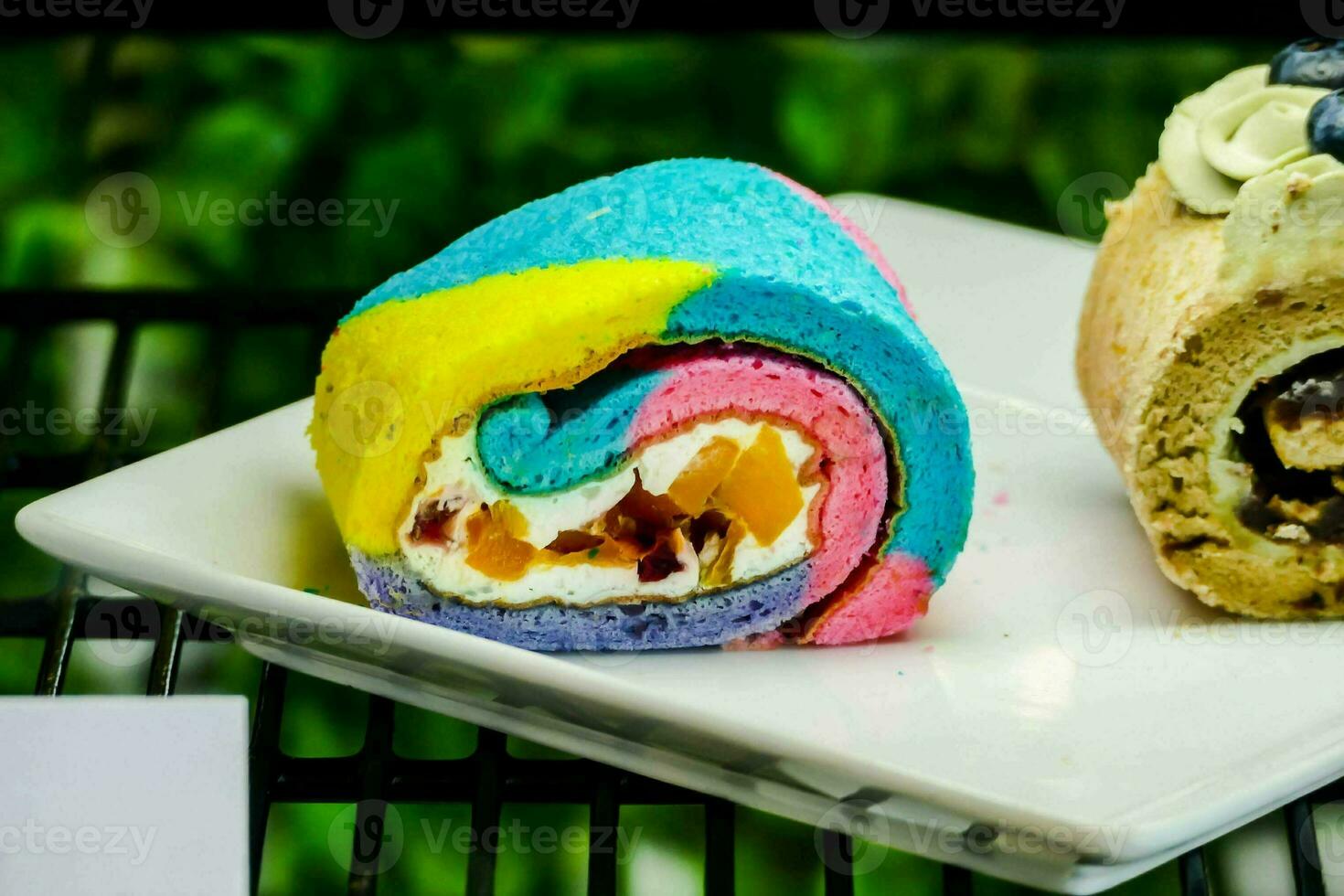 Due colorato Pasticcino rotoli sedersi su un' bianca piatto foto