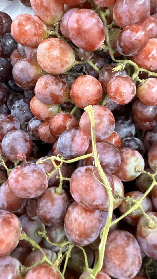 vicino su di crudo biologico dolce rosso uva sfondo, vino uva struttura, salutare frutta rosso vino uva sfondo, superiore Visualizza foto