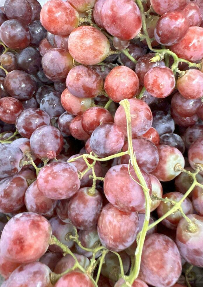 vicino su di crudo biologico dolce rosso uva sfondo, vino uva struttura, salutare frutta rosso vino uva sfondo, superiore Visualizza foto