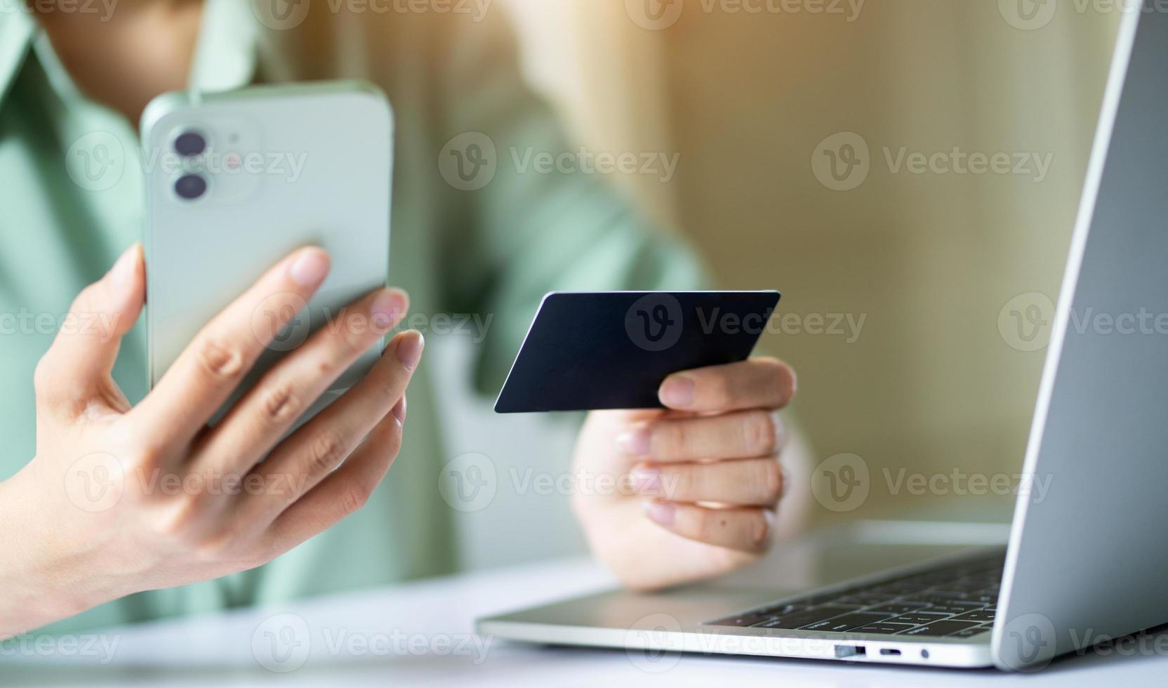 donna asiatica che usa la carta di credito per pagare online foto