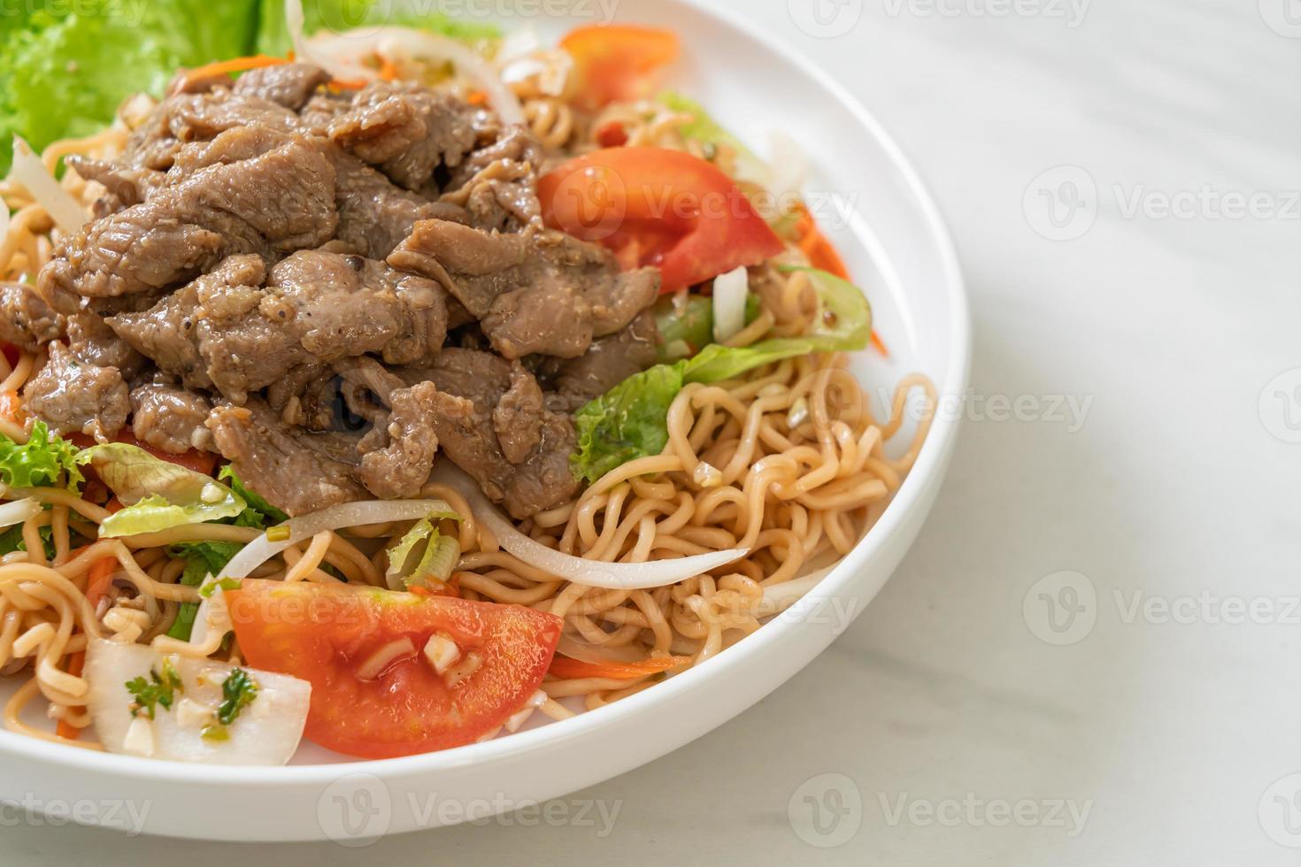 insalata piccante di noodle istantanei con maiale foto