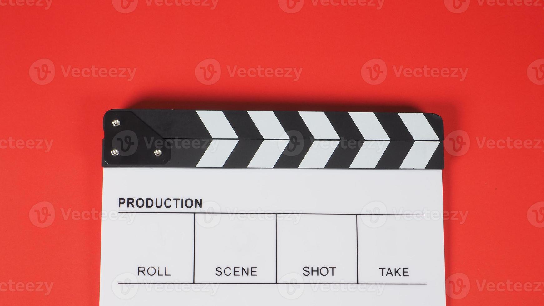ciak o ardesia di film. utilizza nella produzione di video, film, industria cinematografica su sfondo rosso. foto