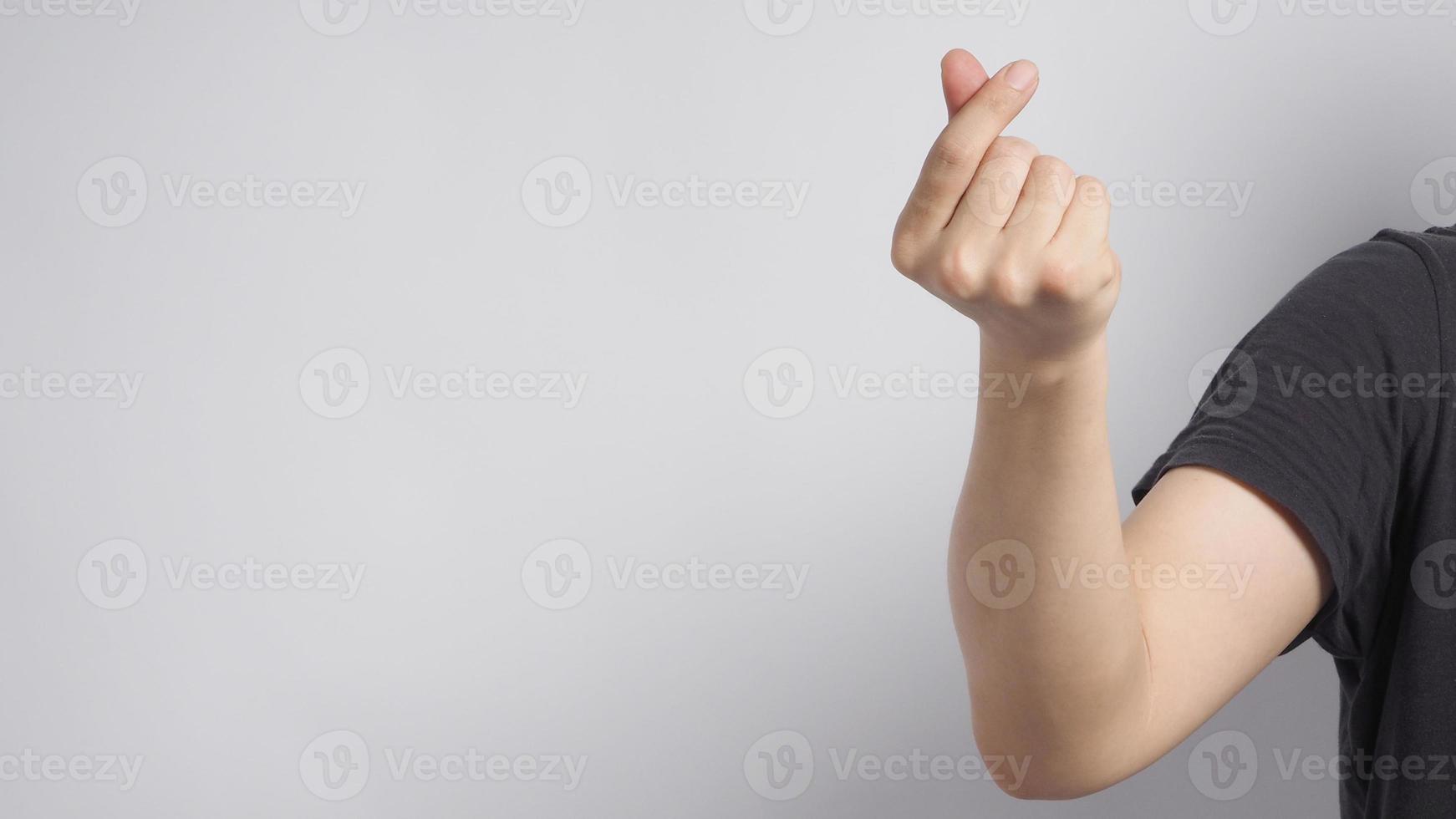 la mano destra maschio sta facendo il segno della mano del cuore mini su sfondo bianco foto