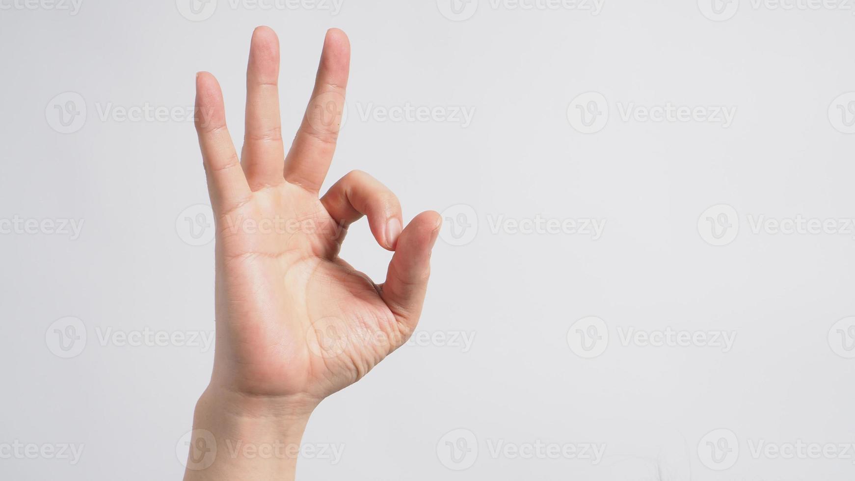 maschio moedl sta facendo un segno di mano ok su sfondo bianco. foto