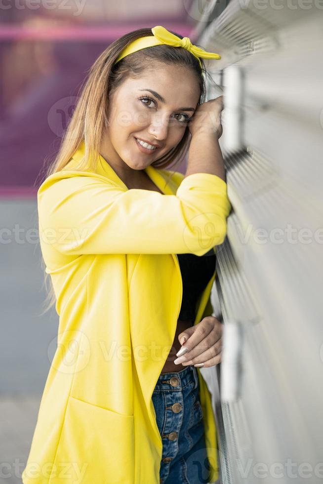 giovane donna che indossa una giacca gialla e una fascia per la testa foto