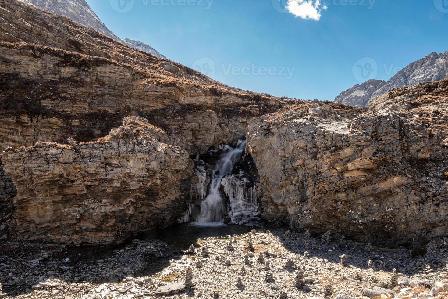 roccia della scogliera con cascata che scorre nel ruscello foto