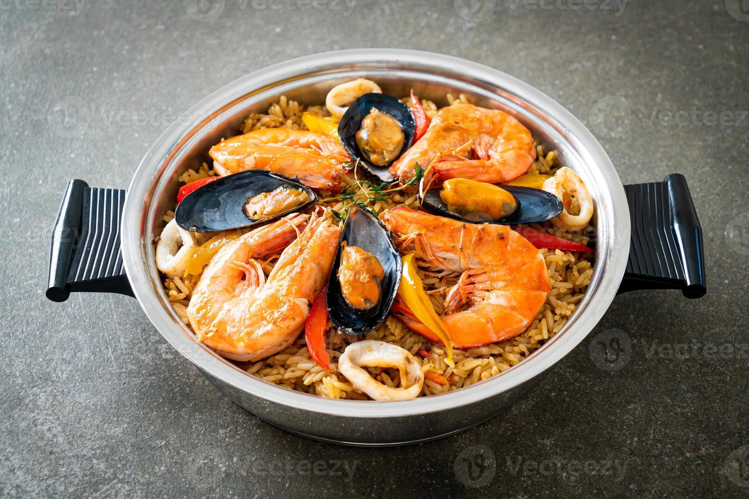 paella di mare con gamberi, vongole, cozze su riso allo zafferano foto