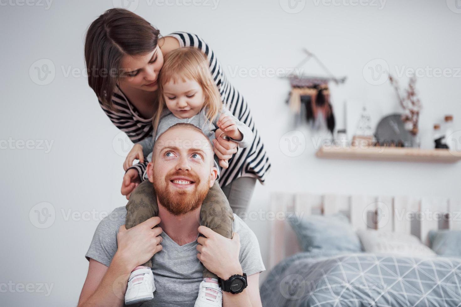 madre di famiglia felice, padre, figlia bambina a casa foto