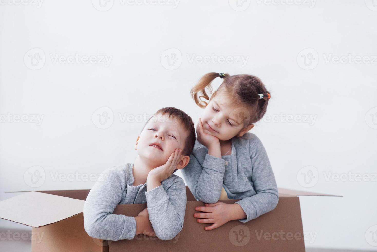 due bambini piccoli ragazzo e ragazza che giocano in scatole di cartone. foto di concetto. i bambini si divertono