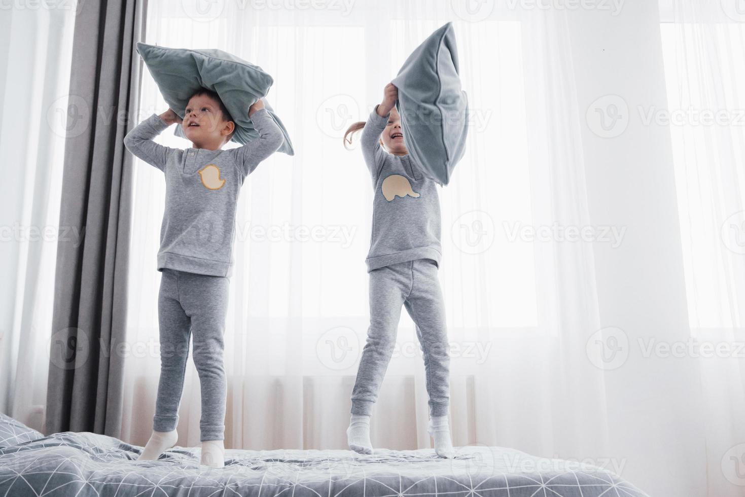 bambini in morbido pigiama caldo che giocano a letto foto