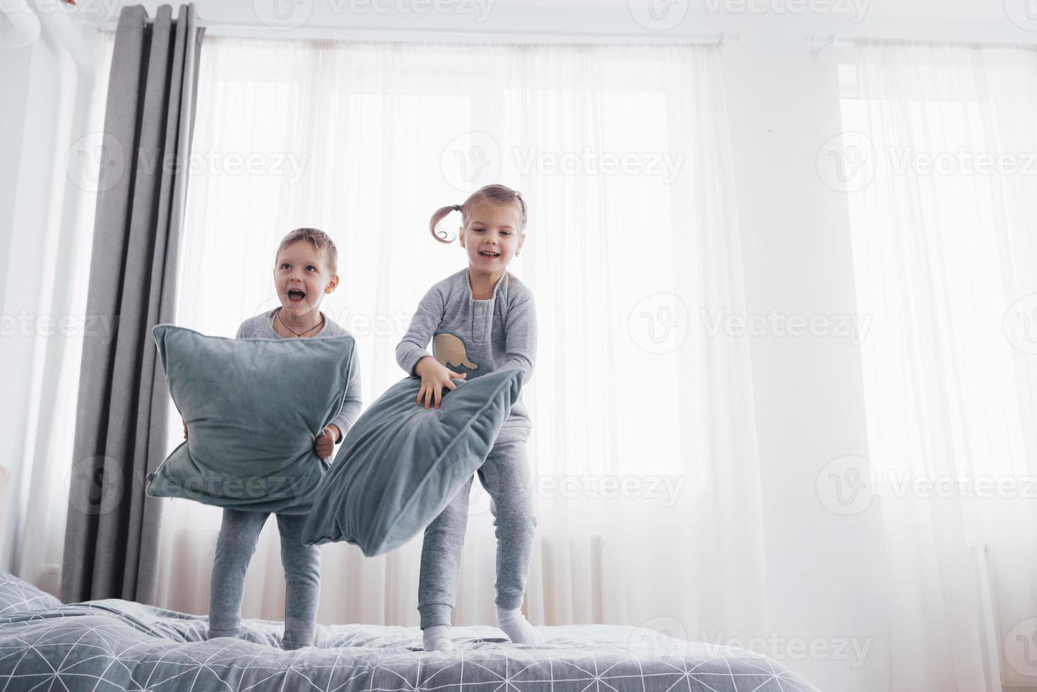 bambini in morbido pigiama caldo che giocano a letto foto
