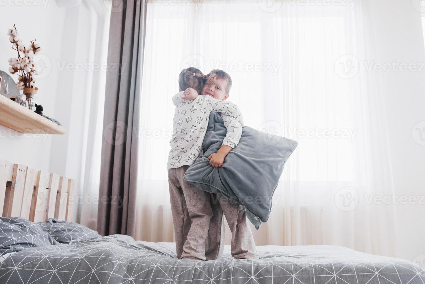 bambini in morbido pigiama caldo che giocano a letto foto