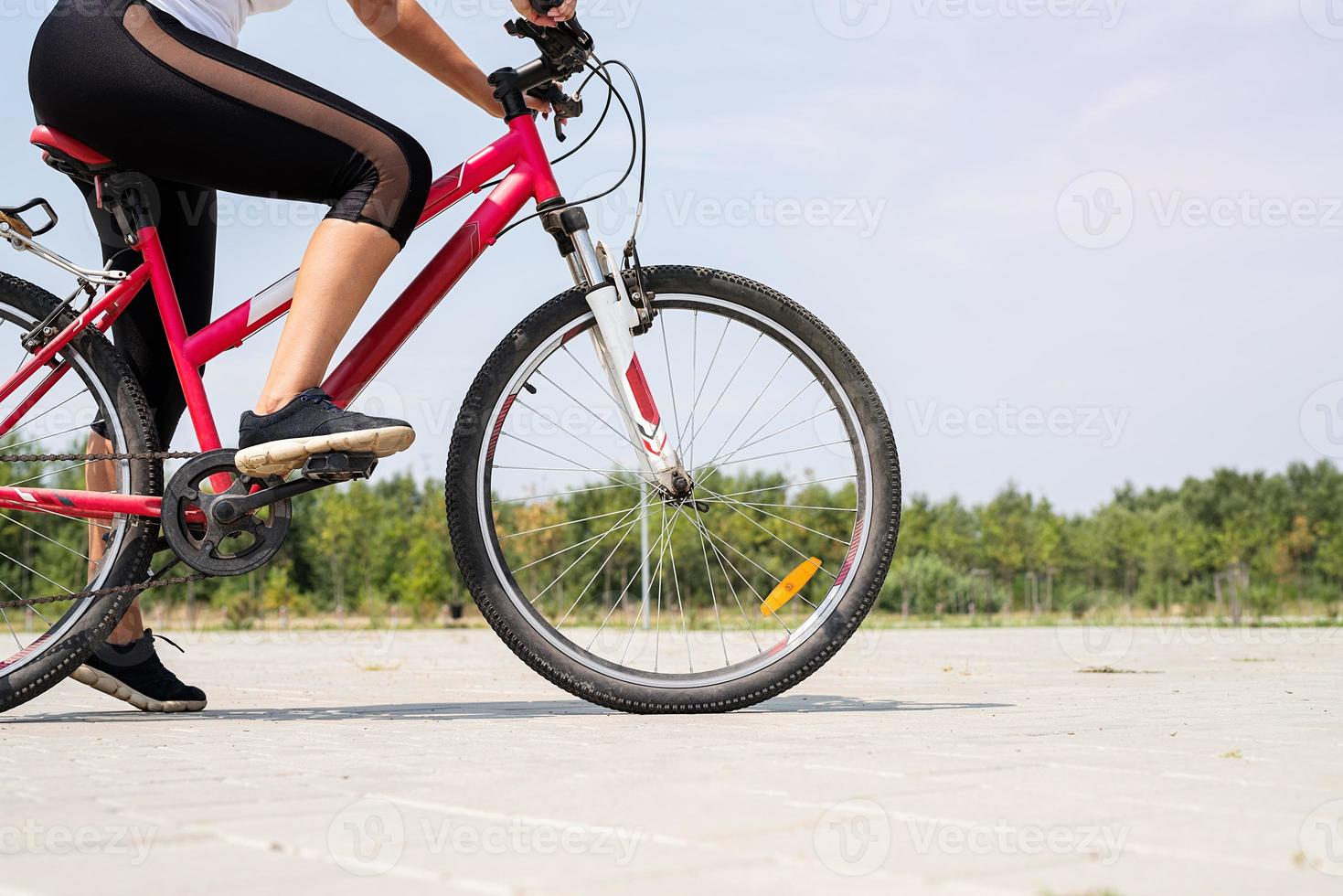 primo piano dei piedi di una donna in sella a una bicicletta foto