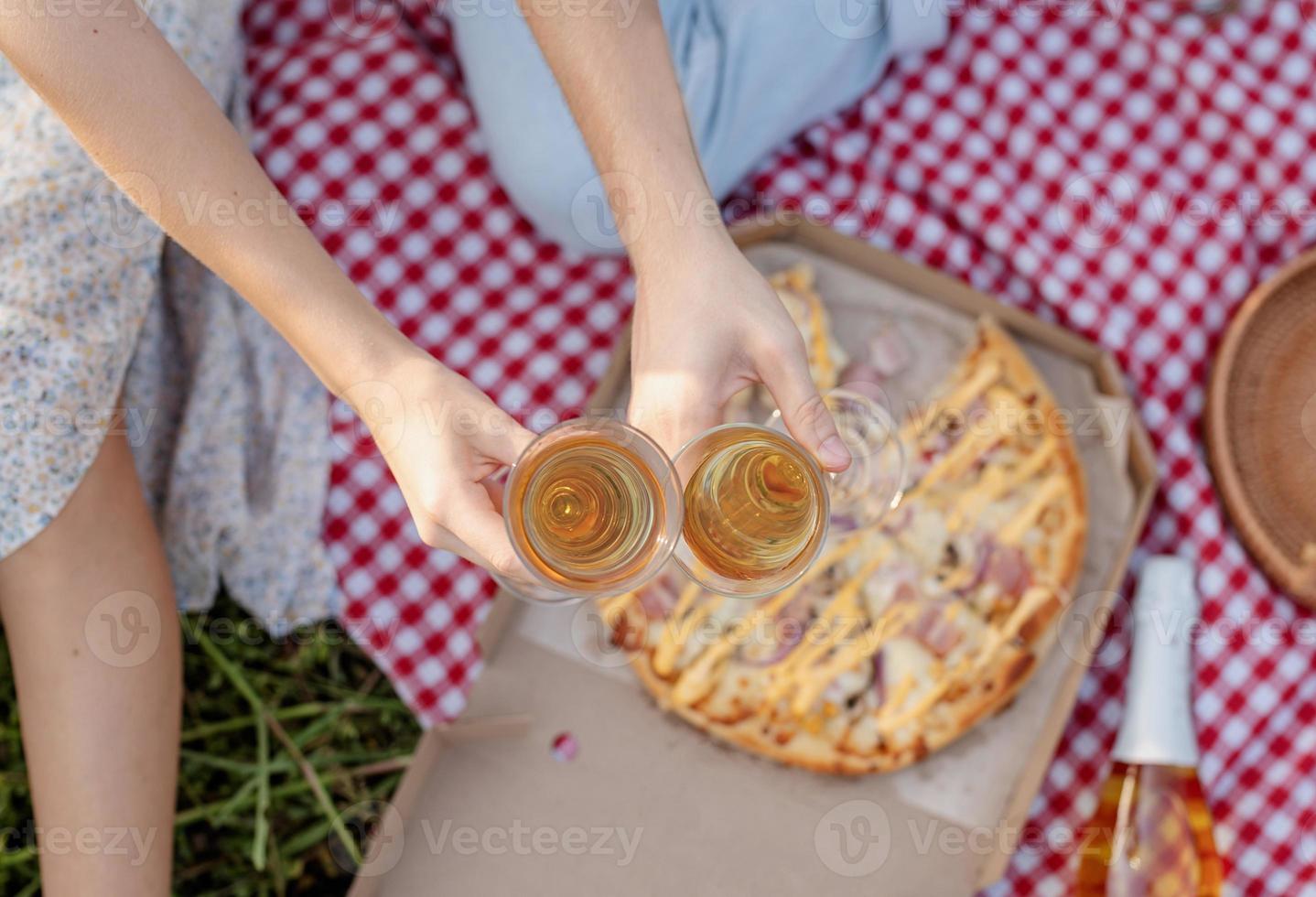 giovane coppia che fa picnic sul campo di girasoli al tramonto foto