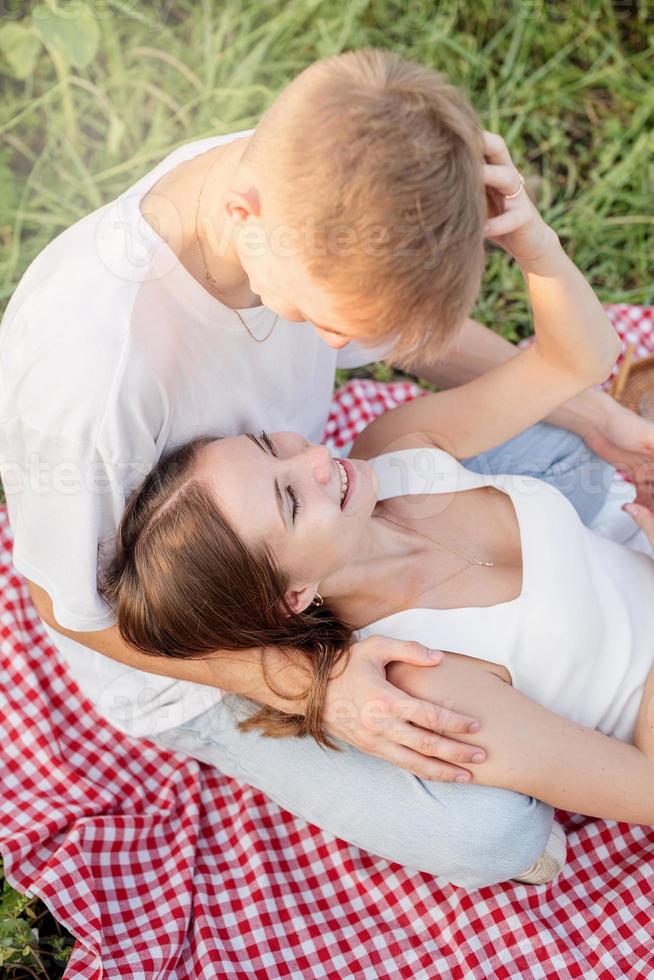 giovane coppia coccole su una coperta da picnic foto