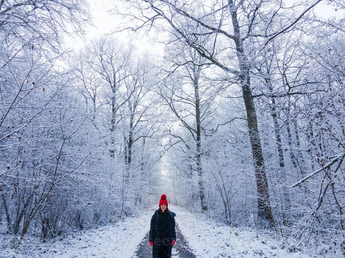 giovane donna con cappello rosso nella foresta invernale foto
