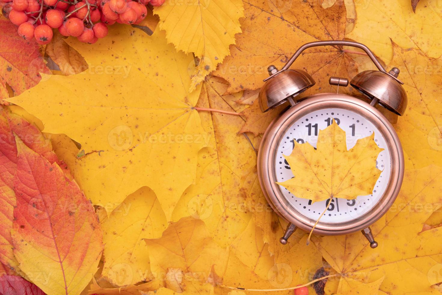 foglie di autunno cadono e sveglia. concetto di tempo autunnale creativo foto