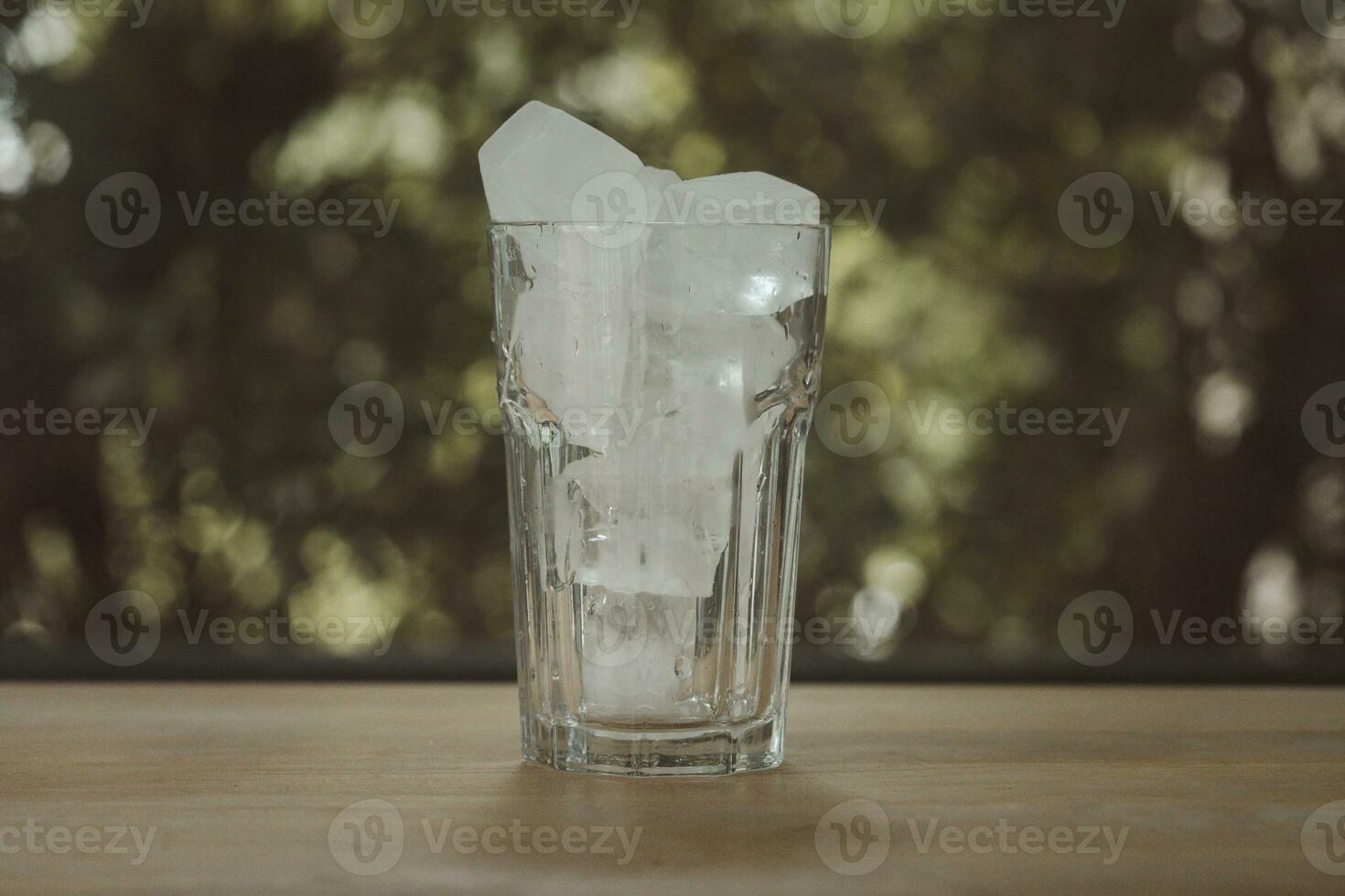 vicino su di trasparente piazza ghiaccio cubi per bevande nel bicchiere. foto