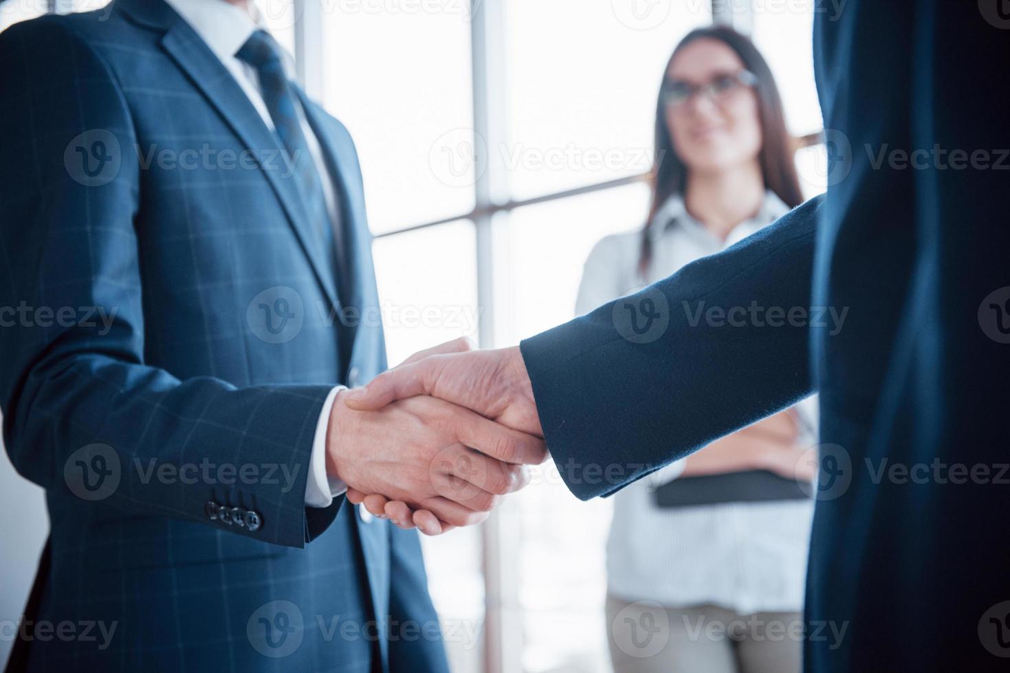 uomini d'affari si stringono la mano, finendo un incontro foto