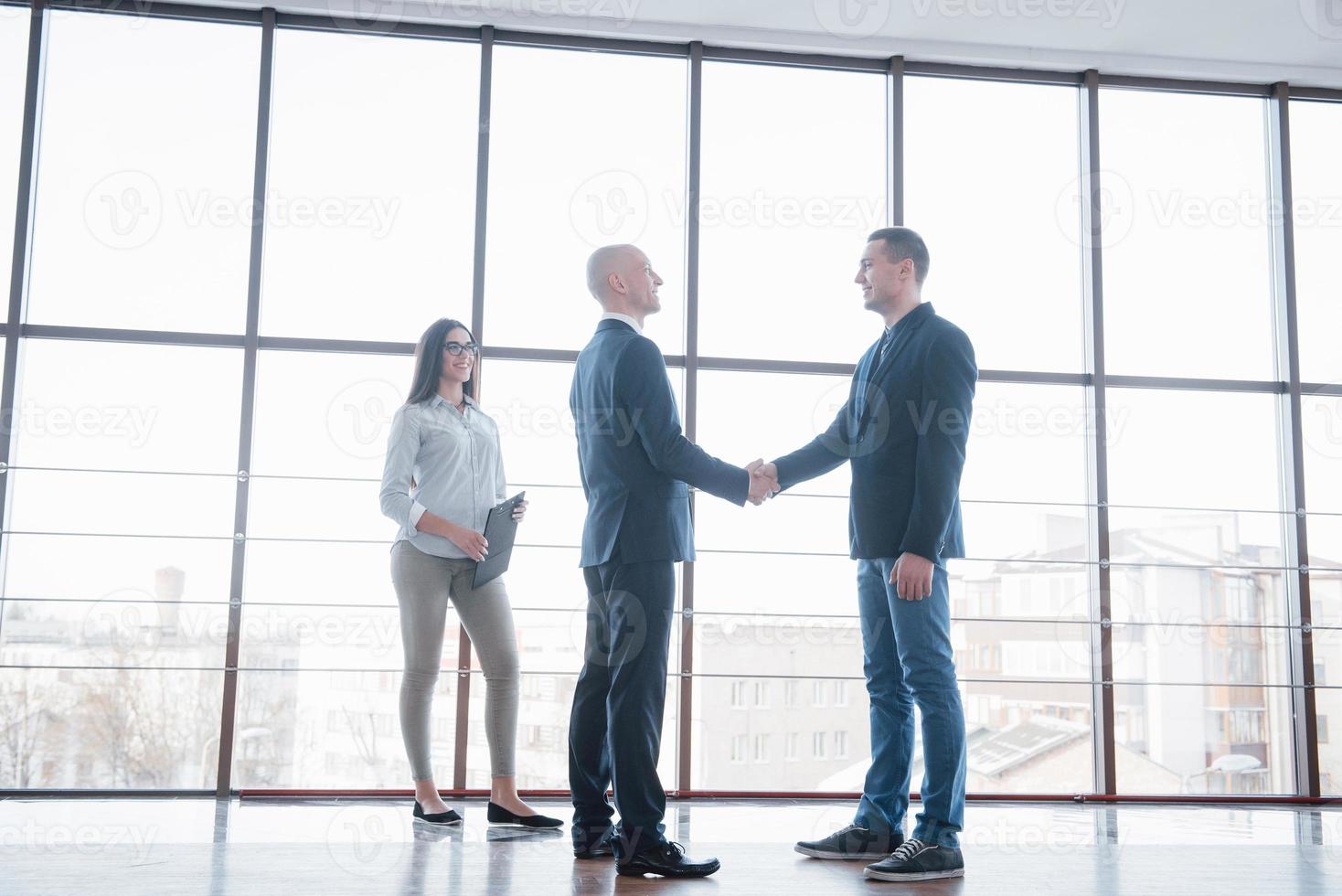 due uomini d'affari fiduciosi che si stringono la mano durante una riunione in ufficio, successo, trattative, saluti e concetto di partner foto