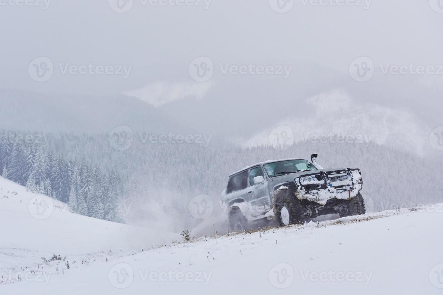 suv cavalca su una montagna invernale guidando rischio di neve e ghiaccio, alla deriva foto