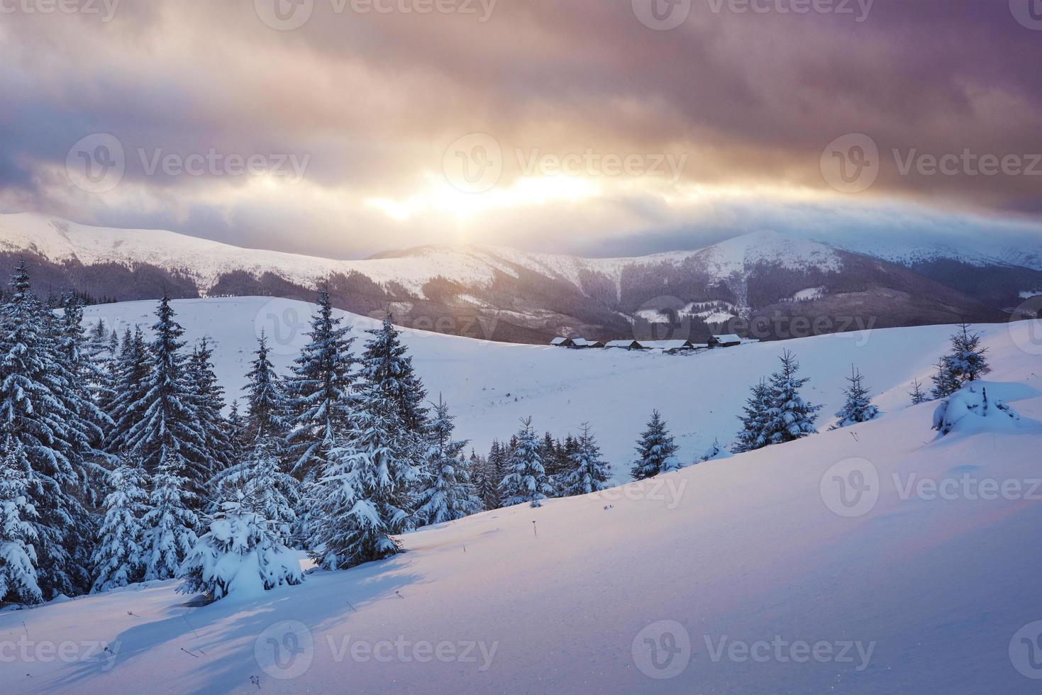 maestoso tramonto in un piccolo villaggio su una collina innevata sotto l'ucraino. villaggi di montagna in inverno. bellissimo paesaggio invernale. carpazi, ucraina, europa foto