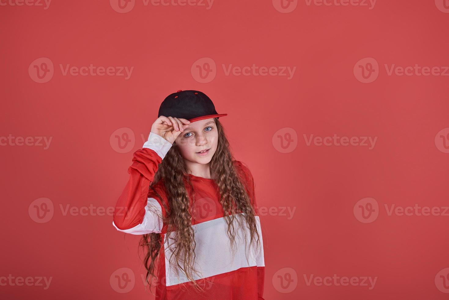 giovane donna urbana che balla su sfondo rosso, moderna e sottile ragazza adolescente in stile hip-hop foto