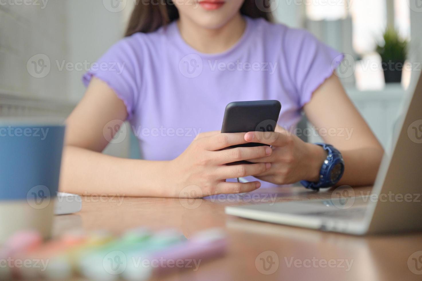 una ragazza che parla online con un amico su uno smartphone durante la pausa dallo studio. foto